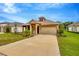 Charming single-Gathering home features manicured lawn, neutral color palette, and two-car garage at 14174 Thoroughbred Dr, Dade City, FL 33525