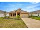 Beautiful single-story home with neutral colors, tidy landscaping, and wide driveway at 14174 Thoroughbred Dr, Dade City, FL 33525