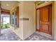 Close up of home's inviting entry with red wood door and surrounding desert color walls at 14174 Thoroughbred Dr, Dade City, FL 33525
