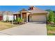 Beautiful home exterior with desert landscaping, a wide driveway, and a two-car garage at 14174 Thoroughbred Dr, Dade City, FL 33525