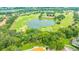 Stunning aerial view of the community golf course, featuring a lake, sand traps, and lush greenery at 14174 Thoroughbred Dr, Dade City, FL 33525