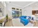 Living room featuring a cozy blue sofa and access to outdoor patio at 14174 Thoroughbred Dr, Dade City, FL 33525