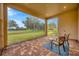 Screened patio with brick flooring, outdoor seating, and a view of the green outdoor space at 14174 Thoroughbred Dr, Dade City, FL 33525