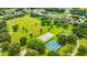 Community park aerial with basketball and pickleball courts near a serene lake and residential area at 14174 Thoroughbred Dr, Dade City, FL 33525