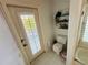 A bathroom with white tile, a toilet, a shower and a door to the outside at 14334 Teasdale Ave, Hudson, FL 34667