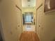 Hallway view to a bathroom with tub, tile floors, and white cabinets, creating a spa-like experience at 14334 Teasdale Ave, Hudson, FL 34667