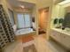 Bright bathroom with a tub, natural light and white cabinets, creating a serene and inviting space at 14334 Teasdale Ave, Hudson, FL 34667