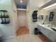 Well-organized bathroom featuring neutral tile flooring, white cabinets, and a convenient towel rack at 14334 Teasdale Ave, Hudson, FL 34667