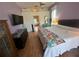 Cozy bedroom with ceiling fan, dresser, television, and an adjacent bathroom for convenience at 14334 Teasdale Ave, Hudson, FL 34667