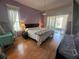 Bright bedroom featuring a large window with natural light, a ceiling fan and laminate floors at 14334 Teasdale Ave, Hudson, FL 34667