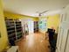 Bedroom featuring laminate flooring, shelving for shoe storage, plantation shutters and a desk with computer at 14334 Teasdale Ave, Hudson, FL 34667