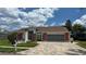Charming single-story home with a brick-accented facade, well-manicured lawn, and a paved driveway at 14334 Teasdale Ave, Hudson, FL 34667