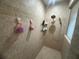 A tiled shower featuring neutral colors and installed shelves for storage of your bath and shower needs at 14334 Teasdale Ave, Hudson, FL 34667