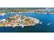 Aerial view capturing waterfront homes with private docks and swimming pools along the coast offering luxurious coastal living at 1493 Sea Gull S Dr, St Petersburg, FL 33707