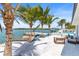 Beautiful backyard features a hammock, modern lounge furniture, and a pool with a boat dock on the water at 1493 Sea Gull S Dr, St Petersburg, FL 33707