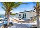 Backyard view featuring an outdoor seating area, a hammock strung between palm trees, and a tranquil waterfront at 1493 Sea Gull S Dr, St Petersburg, FL 33707
