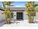 A double front door is framed by palm trees, all accented by pavers and a well-manicured lawn at 1493 Sea Gull S Dr, St Petersburg, FL 33707
