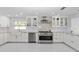 White kitchen features stainless steel appliances, custom cabinets and a decorative backsplash at 1493 Sea Gull S Dr, St Petersburg, FL 33707