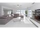Bright living room with water views, sliding glass doors, modern ceiling fan, and a comfortable sectional couch at 1493 Sea Gull S Dr, St Petersburg, FL 33707