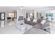 Open-concept living room featuring a fireplace, neutral sectional sofa, and views of the kitchen at 1493 Sea Gull S Dr, St Petersburg, FL 33707