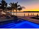 Inviting waterfront pool with modern lounge chairs at sunset reflecting off the pool and channel at 1493 Sea Gull S Dr, St Petersburg, FL 33707