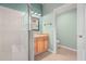 Bathroom featuring a walk-in shower, wooden vanity, and sink with an open doorway to an adjoining room at 19232 Barred Owl Ct, Land O Lakes, FL 34638