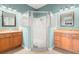 Bathroom featuring dual sinks, a corner shower, and modern fixtures at 19232 Barred Owl Ct, Land O Lakes, FL 34638