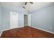 Bedroom with ceiling fan, vaulted ceilings, wood floors, and an open door to another room at 19232 Barred Owl Ct, Land O Lakes, FL 34638