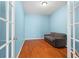 The bedroom with blue walls has wood floors and a gray sofa with a ceiling light fixture at 19232 Barred Owl Ct, Land O Lakes, FL 34638
