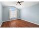 Bright bedroom with wood floors, ceiling fan, vaulted ceiling, and large window with decorative curtains at 19232 Barred Owl Ct, Land O Lakes, FL 34638