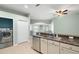 Open kitchen featuring stainless steel appliances, a breakfast bar, sink, and adjacent utility room at 19232 Barred Owl Ct, Land O Lakes, FL 34638