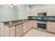 Kitchen features a stainless steel dishwasher, gas range, and refrigerator with light-colored cabinets at 19232 Barred Owl Ct, Land O Lakes, FL 34638
