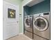 Convenient laundry room featuring modern stainless steel washer and dryer units at 19232 Barred Owl Ct, Land O Lakes, FL 34638