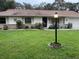Charming single-story home with a well-maintained lawn, complemented by a classic exterior lighting fixture at 1991 63Rd N Ave, St Petersburg, FL 33702