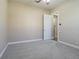 Cozy bedroom with neutral paint, plush carpet, ceiling fan, and a nearby bathroom with a simple aesthetic at 20142 Lace Cascade Rd, Land O Lakes, FL 34637