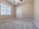 Neutral bedroom featuring plush carpeting, double doors, and a bright window providing natural light and ventilation at 20142 Lace Cascade Rd, Land O Lakes, FL 34637