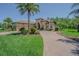 Landscaped front yard with brick driveway leading up to a well-maintained home with lush greenery at 20142 Lace Cascade Rd, Land O Lakes, FL 34637