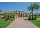 Stunning single-story home boasts a brick driveway, lush landscaping, and a grand entrance with tropical palms at 20142 Lace Cascade Rd, Land O Lakes, FL 34637