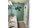 Bathroom features a vanity with a white countertop, sink, decorative butterflies, and dandelion art at 2200 Marshall Dr, Dunedin, FL 34698