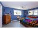 Serene bedroom with two windows, ceiling fan, and vibrant bedding creating a cozy retreat at 2200 Marshall Dr, Dunedin, FL 34698