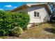 Charming side view of home, complemented by lush greenery and flowering plants along the exterior at 2200 Marshall Dr, Dunedin, FL 34698