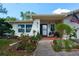Charming single-story home with a well-maintained front yard, green grass, and a lovely garden at 2200 Marshall Dr, Dunedin, FL 34698