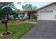 Charming single-story home with a well-maintained front yard, green grass, and a lovely garden at 2200 Marshall Dr, Dunedin, FL 34698