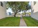 Lush backyard with a walkway leading to a gate accessing the canal and boat docks at 2387 Hanover Dr # 2387, Dunedin, FL 34698