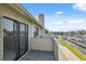 Balcony featuring a waterfront view, with black framed sliding doors, a railing, and grass leading to the water at 2387 Hanover Dr # 2387, Dunedin, FL 34698