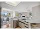 Bright kitchen featuring a breakfast bar, stainless steel dishwasher, and light countertops at 2387 Hanover Dr # 2387, Dunedin, FL 34698
