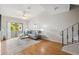 Bright living room with wood floors, ceiling fan, staircase, sliding glass doors to a patio, and modern decor at 2387 Hanover Dr # 2387, Dunedin, FL 34698