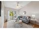 Bright living room with wood floors, ceiling fan, sliding glass doors to a patio, and modern decor at 2387 Hanover Dr # 2387, Dunedin, FL 34698