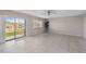 Living room with tile floors, ceiling fan, sliding glass doors to a patio and large window with blinds at 2387 Hanover Dr # 2387, Dunedin, FL 34698