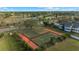 Aerial view of well-maintained tennis courts, surrounded by lush landscaping and trees at 2387 Hanover Dr # 2387, Dunedin, FL 34698